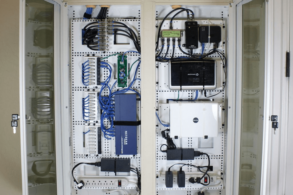 home structured wiring panel open showing network equipment and wiring