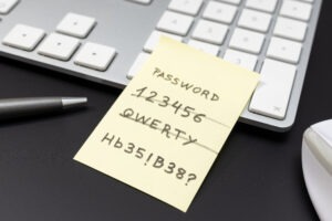 Strong and weak easy Password written on yellow sticky note lying on computer keyboard
