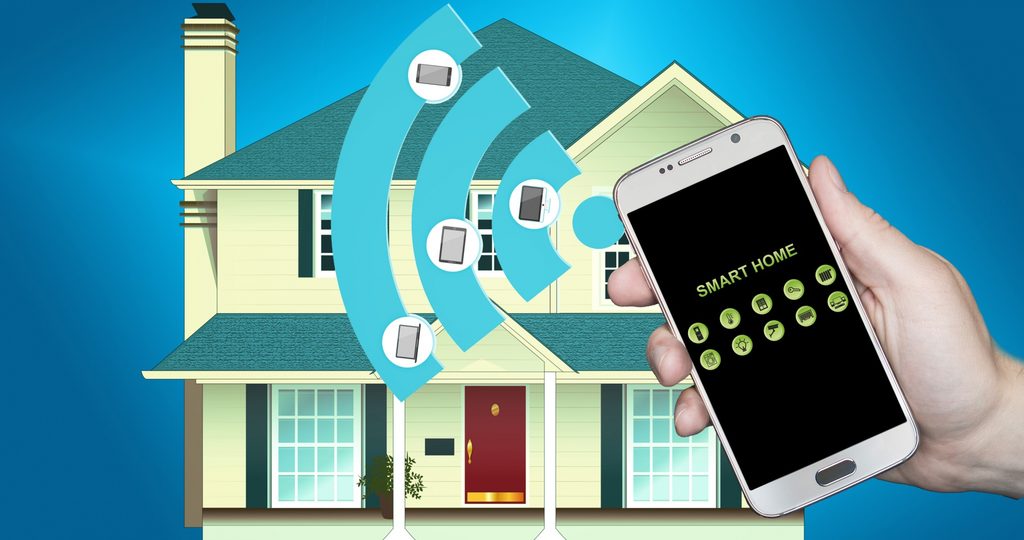 A hand holding a Smart phone with signal that indicates it is controlling a home in the background of the picture